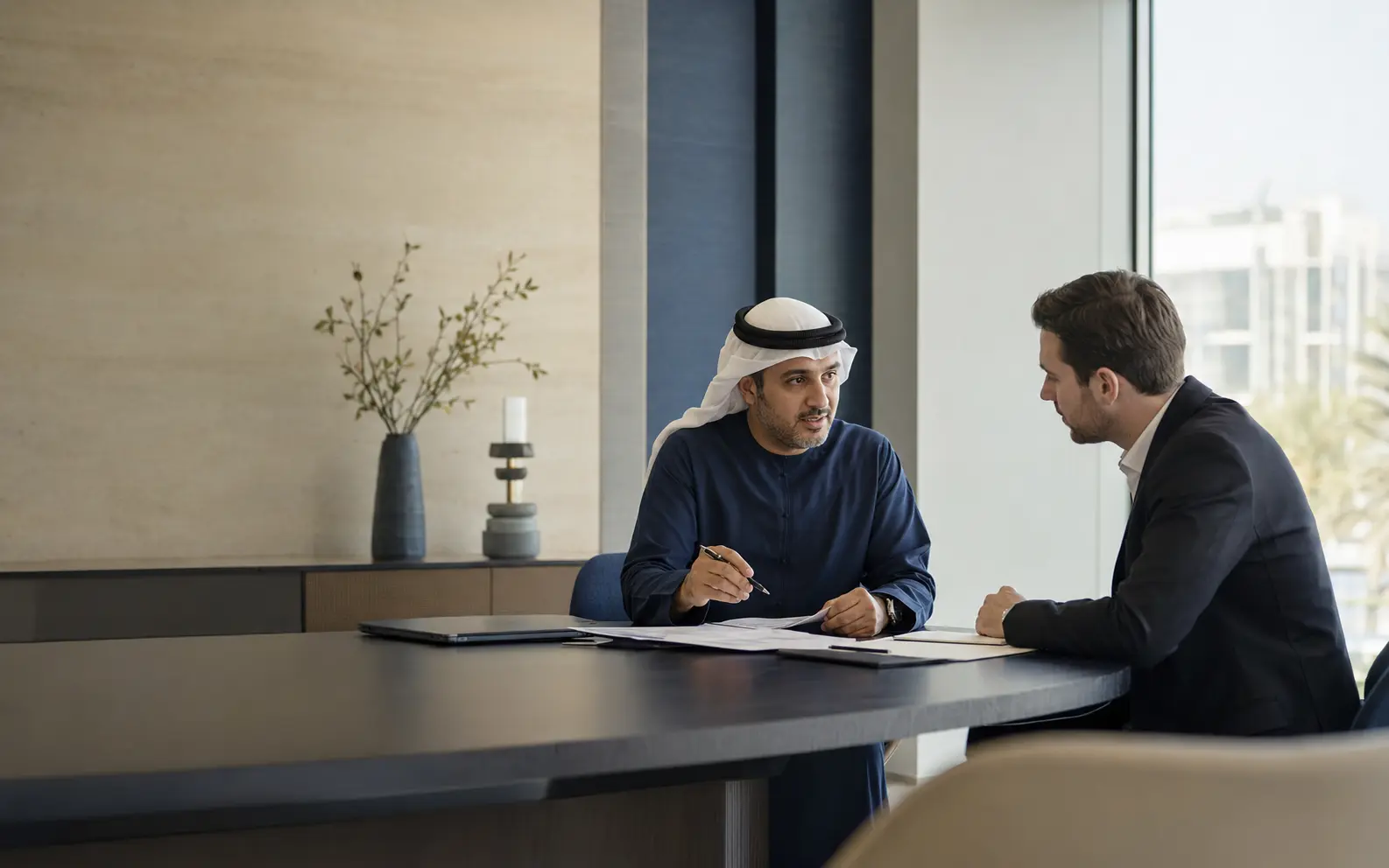 Corporate adviser consulting with an international founder in a modern UAE office